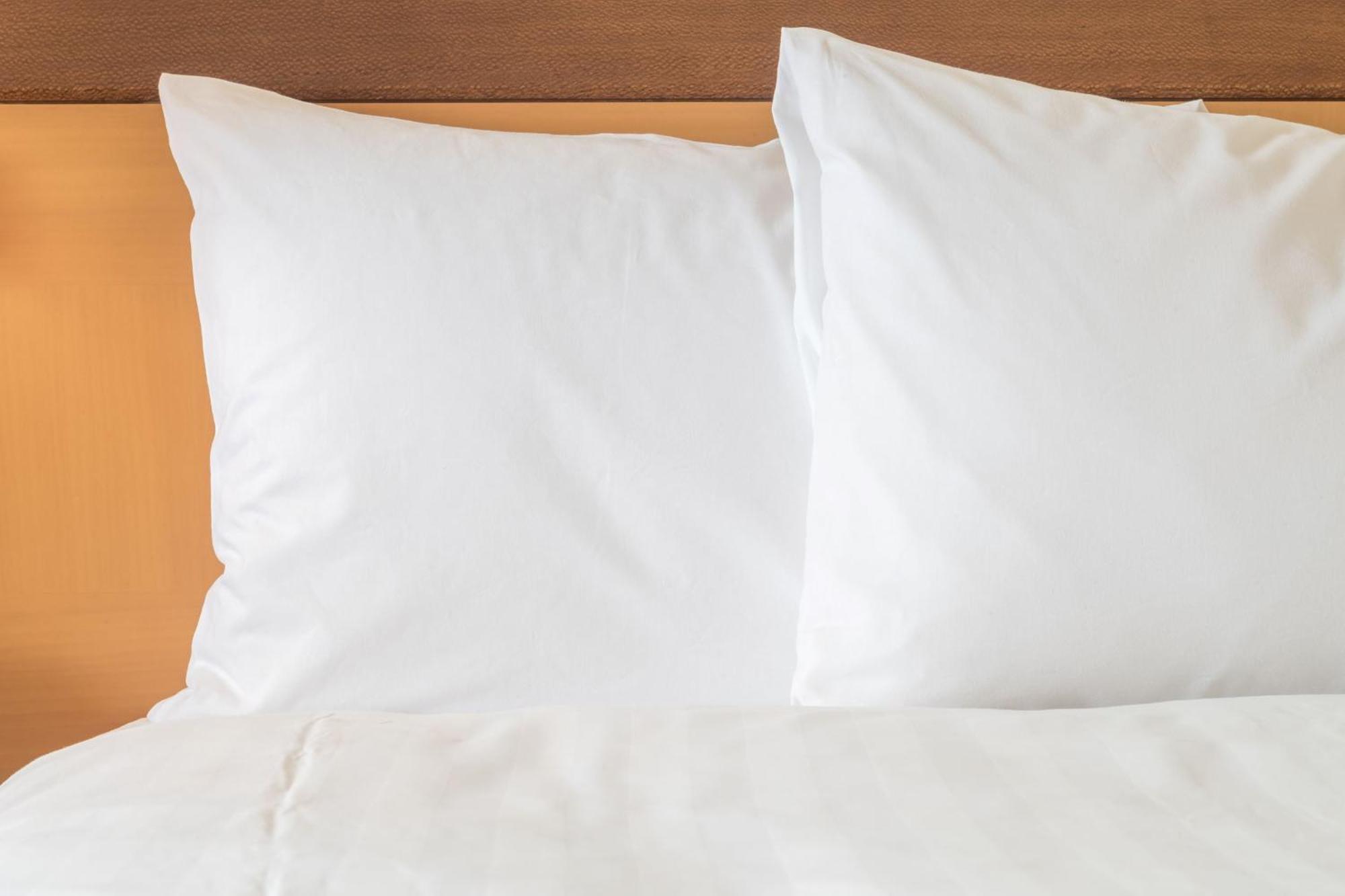 Intercontinental Johannesburg Or Tambo Airport Hotel By Ihg Kempton Park Bagian luar foto Two pillows on a bed
